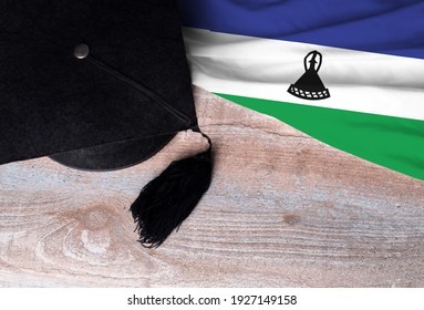 Black Graduation Hat On Lesotho Flag, Education Concept, Top View