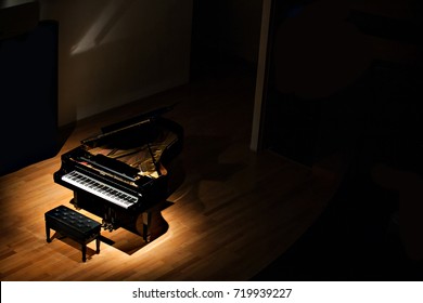 черный рояль в пятно света в темной комнате