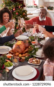 Black Grandfather Making A Toast With His Family At The Christmas Dinner Table, Elevated View