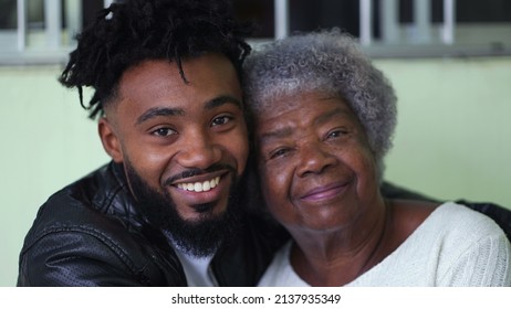A black grandmother and grandson posing together smiling at camera