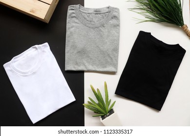 black , gray , white t-shirts with wood box and cactus. rustic background