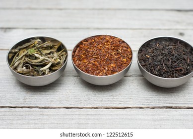 Black, Green, And Rooibos Tea Leaves, Wooden Table Background