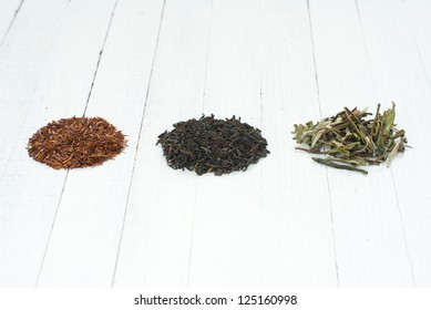 Black, Green, And Rooibos Tea Leaves, Wooden Table Background