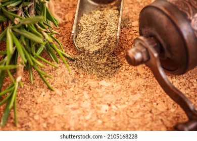 Black Ground Pepper In Metal Scoop, Spice Grinder, Green Rosemary Herb On Cork Wooden Background, Close Up, Copy Space