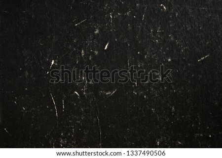 Black grunge cardboard background with scratches and smudges
