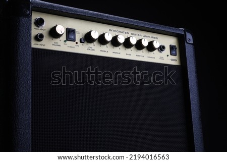 Black guitar amplifier, amp on a black background, close up. Instruments equipment in a rehearsal room.