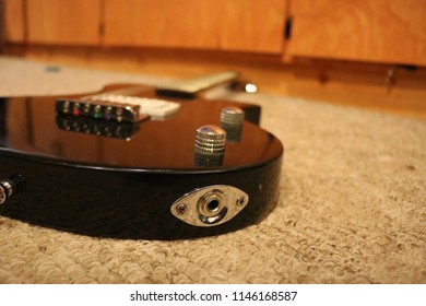 Black Guitar Laying Down On Floor.