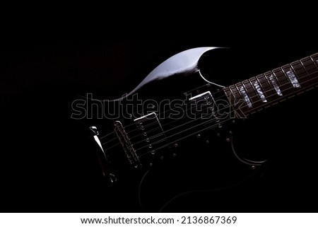 Black guitar on black backdrop