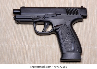 Black gun isolated on light coloured background.
