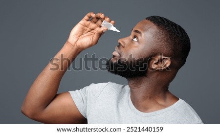 Black guy applying ophthalmology eyedropper. Glaucoma eye prevention, human vision serum wash