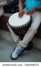 A Black Guy Extracts The Sounds Of A Drum With A Punch, A Street Musician Drums Among The Crowd, An African Plays The Rhythms Of The Tribe. High Quality Photo