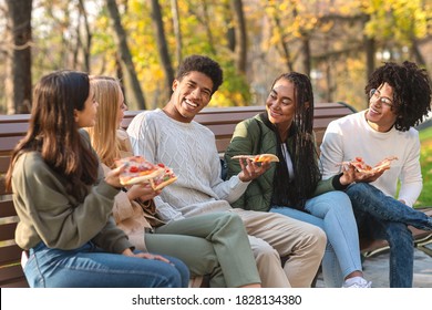 Black guy making funny jokes, eating pizza with friends at park - Powered by Shutterstock