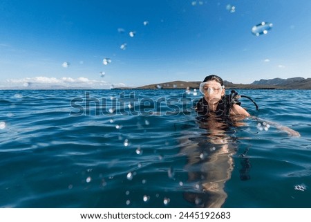 Black hair young and pretty mexican latina Scuba diver on sea surface