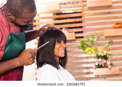 Black Hairstylist Working On A Lady's Hair