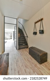 Black Hallway With Wooden Stairway Leading To Second Floor Of Modern Luxury Apartment With Minimalist Interior Design