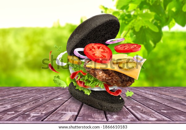 Black\
hamburger with flying ingredients on red\
background