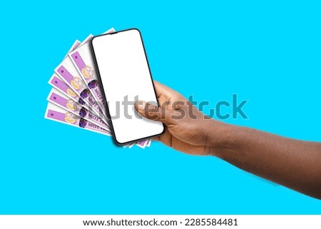 Black hand holding mobile phone with blank screen and Central African cfa franc notes