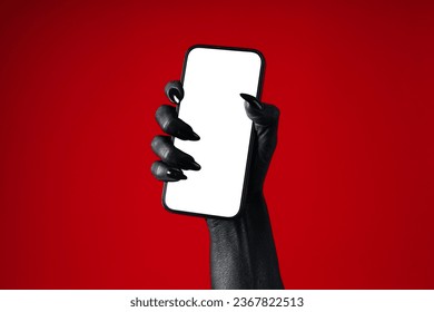 A black hand holds a phone, on a red background.