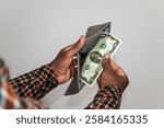 Black hands Holding empty opened men wallet containing single Two US dollar note. hand removing money out of wallet. no money poor person concept 