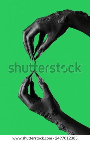 Black hands of witch holding something on green background. Halloween celebration