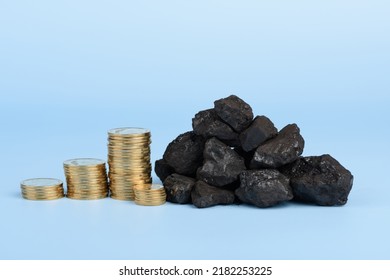 Black Hard Coal With Coins Stacks On Blue Background, Fossil Fuel Price Concept