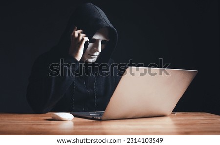 Black hat hacker in hood using tablet on desk to hacking privacy sensitive data cyber crime hack in dark room background matrix binary code. Cyber security cyber crime concept. Hacking phishing
