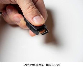 a black hdmi cable is clutched in the man's hand. cable to connect the home media