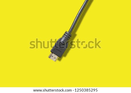 Black HDMI cable for connection between TV and laptop isolated on yellow background
