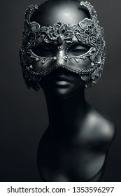 Black head of mannequin in creative metal mask with jewels 