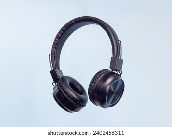 Black headphones on a blue background. Minimal concept. Mock-up. Music. Levitation. - Powered by Shutterstock