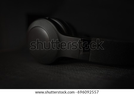 Black headphones on black dark background