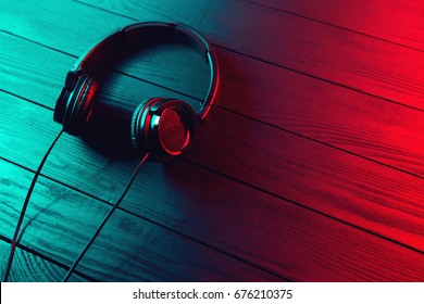 Black headphones on dark wooden background. Vintage style - Shutterstock ID 676210375