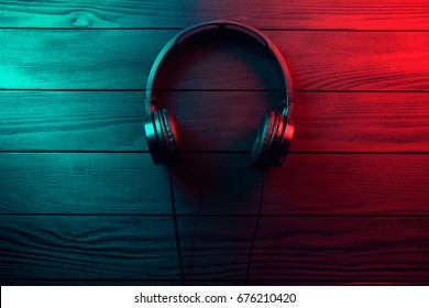 Black headphones on dark wooden background. Vintage style