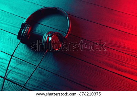 Black headphones on dark wooden background. Vintage style