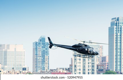 Black Helicopter Hovering Over New York Buildings.