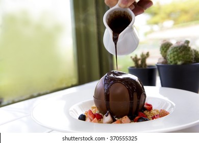 Black Hot Chocolate Pouring Onto A Chocolate Ball