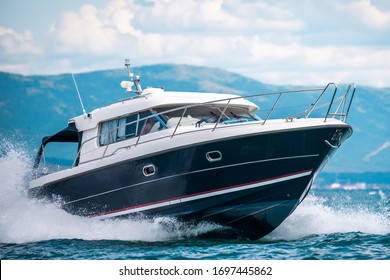 A Black Hull Speedboat Racing By Sea