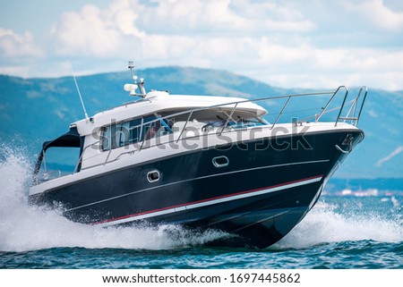 A black hull speedboat racing by sea