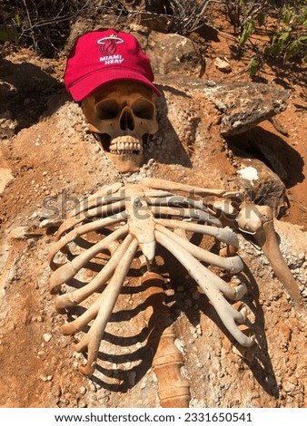black humor with a skeleton as a warning sign to take enough water with you on the trail into the rugged inhospitable wilderness to avoid the danger of dehydration when you get lost in the hot climate
