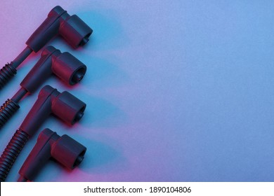 Black Ignition Wires Of A High Voltage For Spark Plug On Blue And Red Background. Car Parts. Top View.