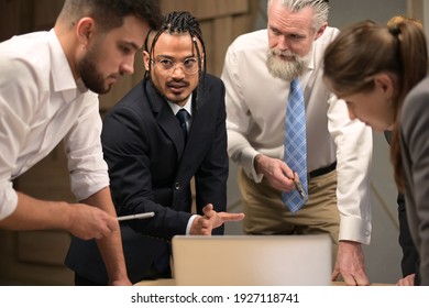 A black Indian guy expresses his opinion on a work issue at a meeting with colleagues in the office, close-up. People of different nationalities and ages work together - Shutterstock ID 1927118741