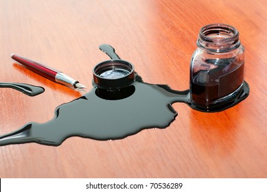 Black Ink Spill Near Red Pen On  Table