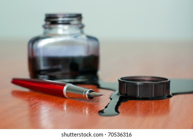 Black Ink Spill Near Red Pen On  Table