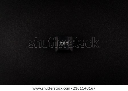 black insert button from keyboard on black background with copy space.