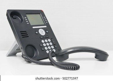 Black IP Phone and handset on the white table