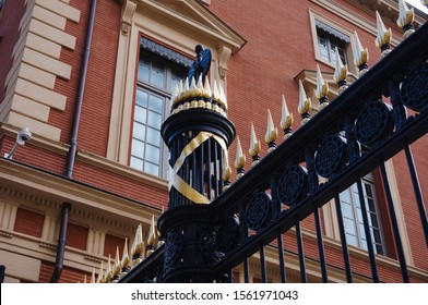 Black iron cast gate with golden spearhead and Roman fasces in front of the brick-built building of the Court of Appeals of Toulouse, France, in Salin Square (part of the Palace of Justice)