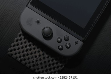 black Joycon controller on a black table. Perfect for gaming enthusiasts and Nintendo fans. This photo captures the essence of entertainment and fun.