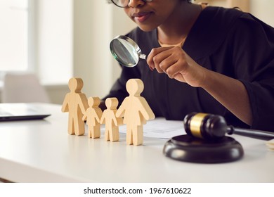 Black Judge Or Lawyer Looking In Magnifying Glass At Little Mom, Dad Children Figures On Desk. Family Law Court Case Investigation, Divorce, Joint Custody Of Kid, Parental Rights Deprivation Concept