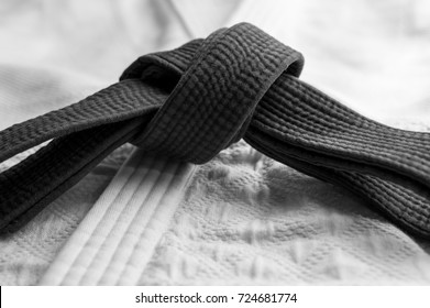 Black Judo, Aikido Or Karate Belt On White Budo Gi. Concept Is Applicable To Sports, Business Or Education