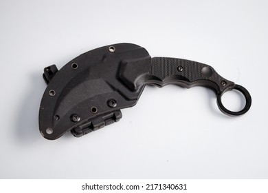 black karambit knife with holster on white background. 